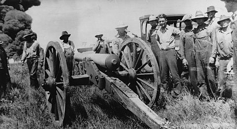 Oilfield cannon firing at burning oil tanks in Kansas.