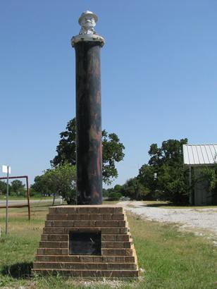 Joe Roughneck plaque and statue on oil pipe in Boonsville, Texas. 