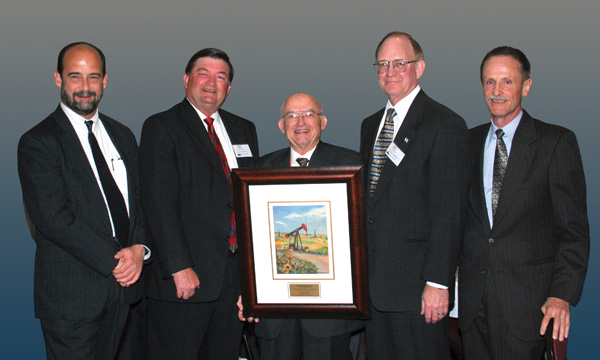Among those who have served on the editorial staff at The American Oil & Gas Reporter with founder Charles W. “Cookie” Cookson (center) are, from left, Bruce Wells, Alex Mills, Bill Campbell and A.D. Koen. Cookson is holding the artist’s proof of a limited edition print, “Donkey in a Kansas Field,” by California artist JoAnn Cowans, which was presented to Cookson by the American Oil & Gas Historical Society, which honored Cookson with its first AOGHS-Petroleum History Institute Oil History Journalism Award in April 2006. Wells founded AOGHS in 2003 and continues to serve as its executive director. Mills is president of the Texas Alliance of Energy Producers; Campbell remains with The American Oil & Gas Reporter as managing editor; and Koen is an independent energy writer and communications consultant in Houston.
