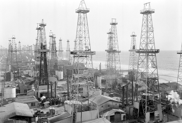 The size of oilfields in Los Angles, Venice and Huntington beaches, and Midway-Sunset, enticed companies to risk everything on remote "wildcat" wells. Taken two years after discovery of the Vince Beach oilfield two blocks from the ocean, this 1931 photograph looks east down Wilshire Boulevard. 
