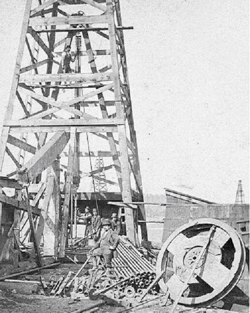 Circa 1880s wooden cable-tool derrick, bull wheel and workers.