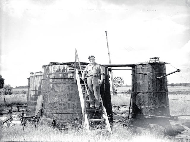Lime, Ohio, oilfield workers at wooden storage tanks.