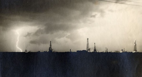 June-13-This-Week-Hobbs-NM-AOGHS Lightning strikes near derricks on the stormy horizon at the Hobbs, New Mexico, oilfield.